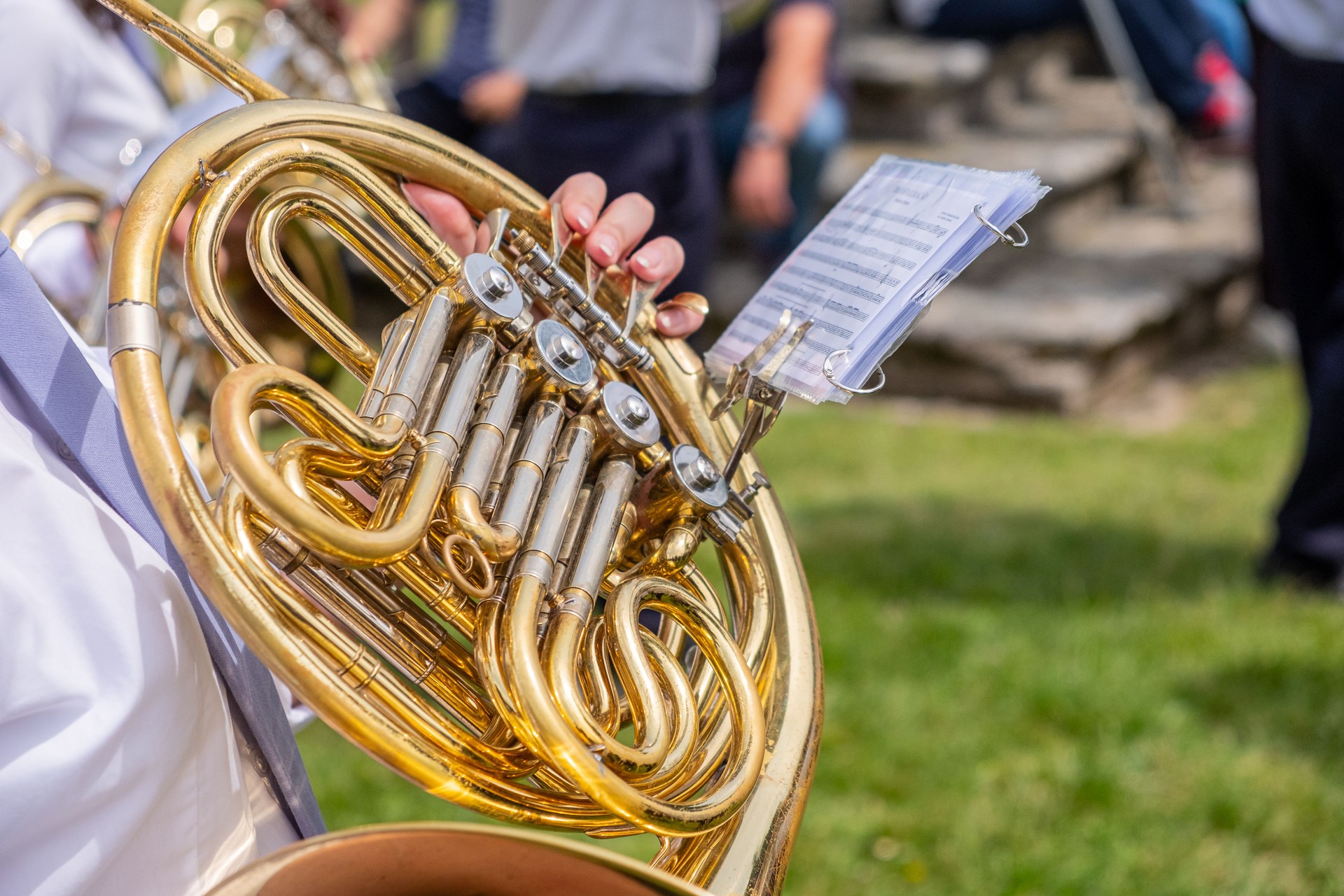 a musician playing the horn in a marching band at an outdoor concert
